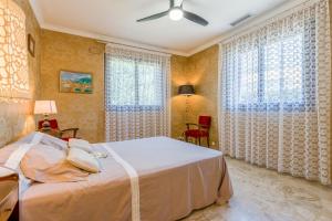 a bedroom with a bed and two windows at La Villa D'antan - Piscine in Nyons