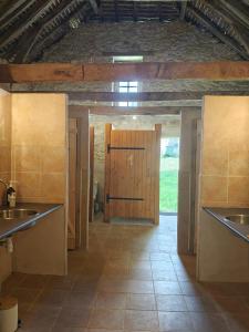 a kitchen with a wooden door and a tile floor at Camping and Gîtes - Le Mas d'Ayen in Ayen +54 photos