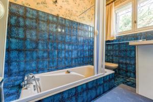 a blue tiled bathroom with a tub and a sink at La Villa D'antan - Piscine in Nyons +19 photos