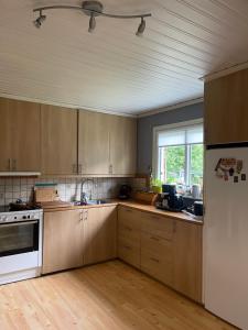 a kitchen with wooden cabinets and a white refrigerator at Zuzanna in Storebro