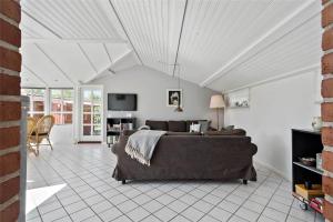 a living room with a couch and a tv at R624-Rodvig-Stevns-Strandvaenget-6 in Rødvig