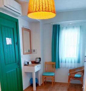 a room with a green door and a table and chair at Felicitta Stay & Joy in Seferihisar