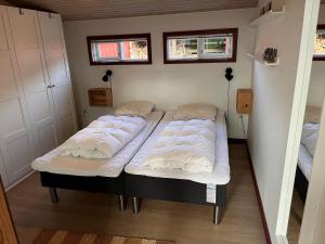 two twin beds in a small room with two windows at R624-Rodvig-Stevns-Strandvaenget-6 in Rødvig