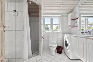 a white bathroom with a toilet and a sink at R624-Rodvig-Stevns-Strandvaenget-6 in Rødvig +12 photos