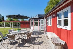 a patio with a table and chairs and an umbrella at R624-Rodvig-Stevns-Strandvaenget-6 in Rødvig