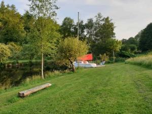 a field of grass with a boat in the distance at Bateau Gîte in Berné +9 photos
