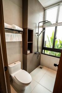 a bathroom with a toilet and a window at Nhiên Hotel in Ho Chi Minh City