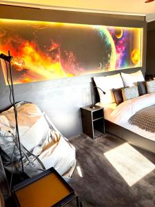 a bedroom with a bed and a painting on the wall at Sleephotels Cosmos in Hamburg