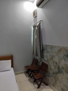 a room with a bed and a wooden chair in it at Khách Sạn Lâm Tiên - Lam Tien Hotel in Bùi Tiếng