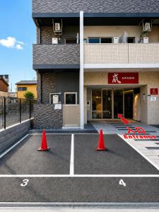 two orange cones in a parking lot in front of a building at Hotel Arashi Tengachaya No005 in Osaka