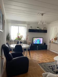 a living room with a table and a tv at Zuzanna in Storebro