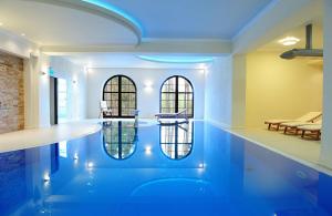 a swimming pool in a house with blue lighting at Hotel Kazimierski Zdrój in Janowiec