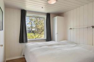 a bedroom with a white bed and a window at 1352-Vestervig-Isfuglevej-19 in Vestervig