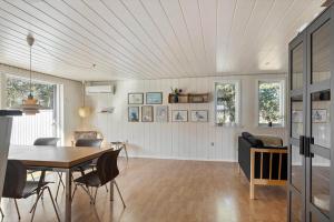 a dining room and living room with a table and chairs at 1352-Vestervig-Isfuglevej-19 in Vestervig
