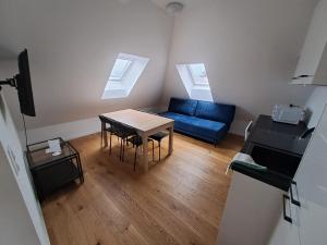 a living room with a blue couch and a table at Krems am Campus in Krems an der Donau
