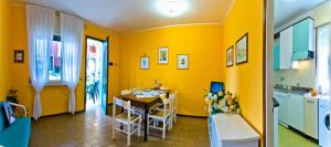 a kitchen with a table and a yellow wall at Luca in Bibione