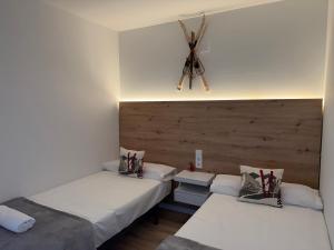 a room with two beds and a ceiling fan at Apartamentos Leyre Candanchú in Candanchú