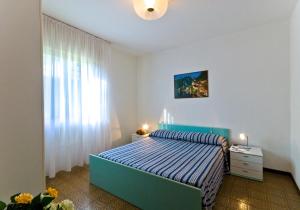 a bedroom with a blue bed and a window at Luca in Bibione