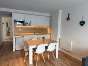a kitchen and dining room with a table and chairs at Apartamentos Leyre Candanchú in Candanchú