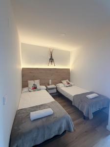 two beds sitting in a room with at Apartamentos Leyre Candanchú in Candanchú