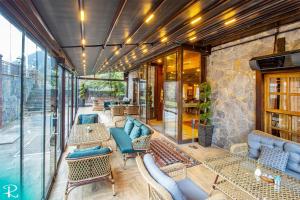an outdoor patio with chairs and tables and windows at Royal Uzungol Hotel&Spa in Uzungöl