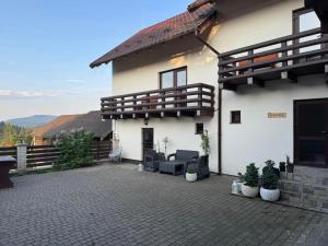 biały dom z krzesłami i patio w obiekcie Hotel White House w mieście Mānma
