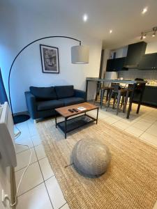 a living room with a blue couch and a table at Dax Fontaine Chaude Center in Dax +26 photos