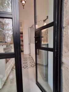 a glass door to a kitchen with a refrigerator at The Pearl in Talbyeh in Jerusalem