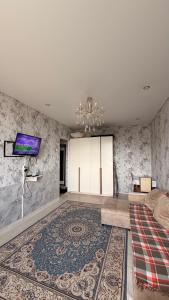 a bedroom with a bed and a tv on a wall at Квартира Алимжанова 16 Балхаш in Balqash