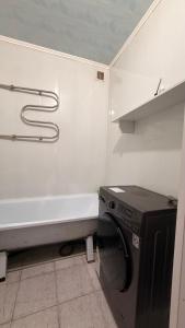 a white bathroom with a washing machine and a tub at Квартира Алимжанова 16 Балхаш in Balqash