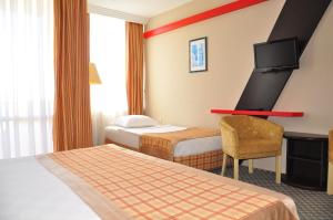 a hotel room with two beds and a desk at Senza Sunset Beach Hotel in Alanya