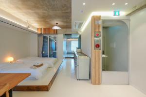 a bedroom with two beds and a wooden table at 스테이머묾 m2 in Jeonju