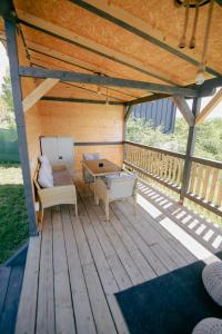 a wooden patio with a table and chairs on a deck at SkyAtlas Hideaway in Sohodol +74 photos