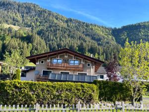 a house with a fence in front of a mountain at Ferienwohnung Wieser in Sankt Jakob in Haus