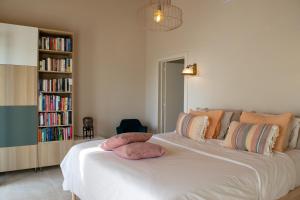a bedroom with a large white bed with a book shelf at Boutique Guesthouse-Moncarapacho in Moncarapacho +21 photos