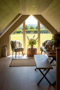a room with an attic with a large window at The Stable in Clack