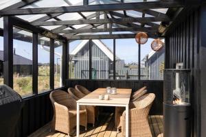 a patio with a table and chairs on a deck at 1369-Thisted-Nordsovej-94 in Nørre Vorupør