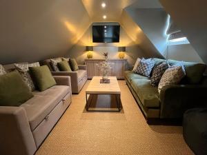 a living room with two couches and a coffee table at The Stable in Clack