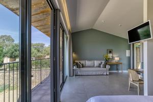 a living room with a couch and a balcony at Mas Cusi in Palau-Saverdera
