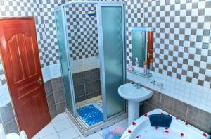 a bathroom with a shower and a toilet and a sink at Residence Next Door-5 in Nairobi