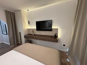 a bedroom with a tv on the wall and a bed at Villa Nora in Tučepi