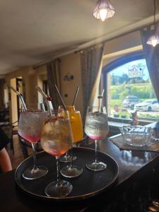 four wine glasses on a tray on a table at hotel il ghiro in Ovindoli