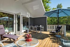 a patio with chairs and a table and an umbrella at OH293-Hadsund-Jaegerskoven-15 in Hadsund
