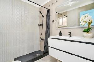 a white bathroom with a shower and a sink at Exclusivo apto. Solparaiso-Jacuzzi in Torrox +26 photos