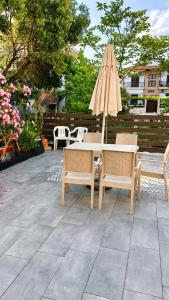 a table and chairs with an umbrella and a table at Villa Maria in Ierissos