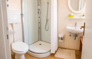 a bathroom with a shower and a toilet and a sink at Hotel Le Ali in Rimini