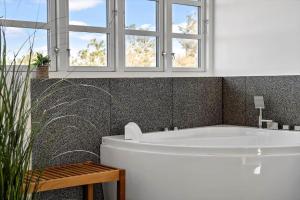 a white bath tub in a bathroom with windows at 1073-Thisted-Orhagevej-30 in Klitmøller +12 photos