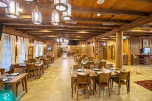a dining room with wooden tables and chairs at Royal Uzungol Hotel&Spa in Uzungöl