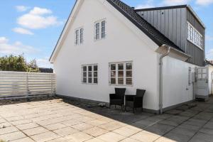 a white house with two chairs on a patio at 1073-Thisted-Orhagevej-30 in Klitmøller