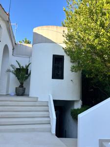 a white building with stairs and a window at Apartments Peace&Love in Baška